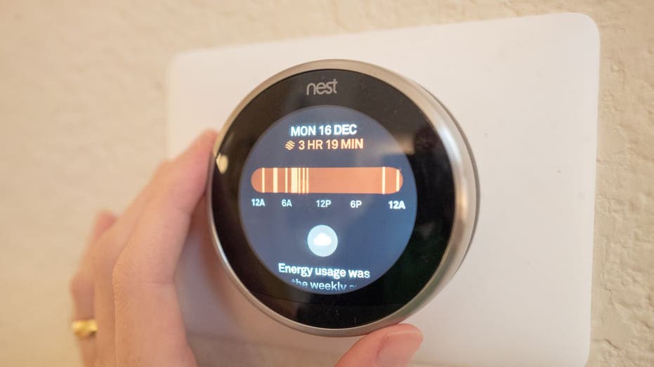 Customer adjusts the dial on a smart thermostat