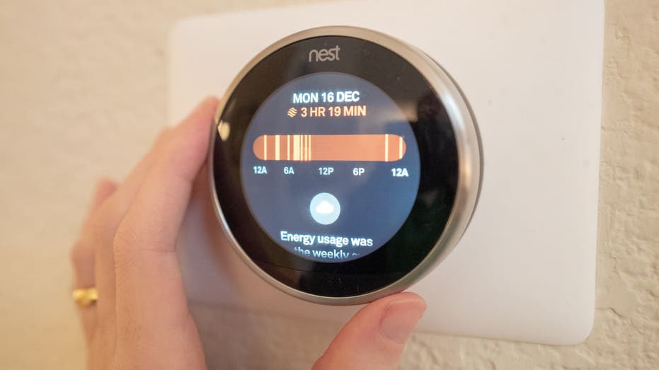 Customer adjusts the dial on a smart thermostat