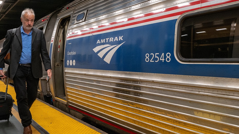 A passenger walks to an Amtrak train