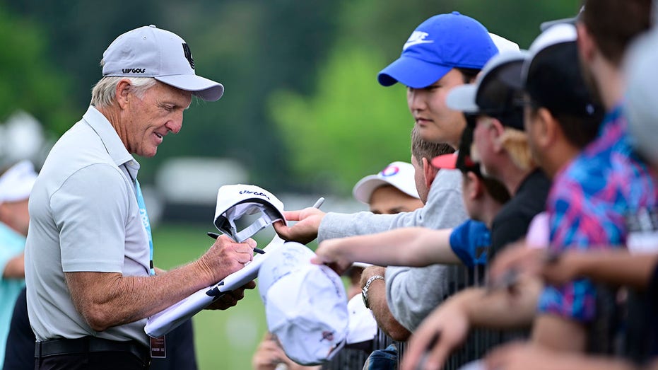 Greg Norman signs autographs