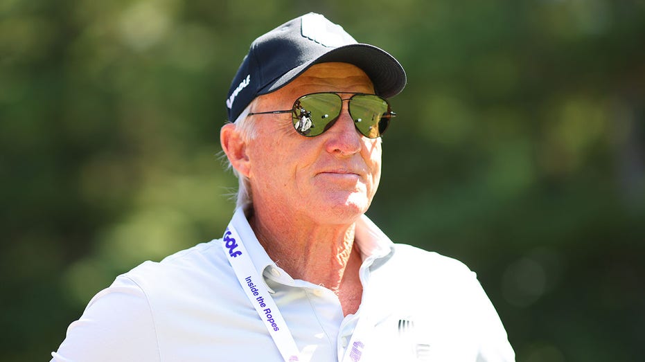 Greg Norman looks on from the practice range