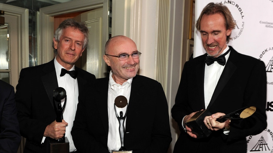 Genesis members smiling, holding awards