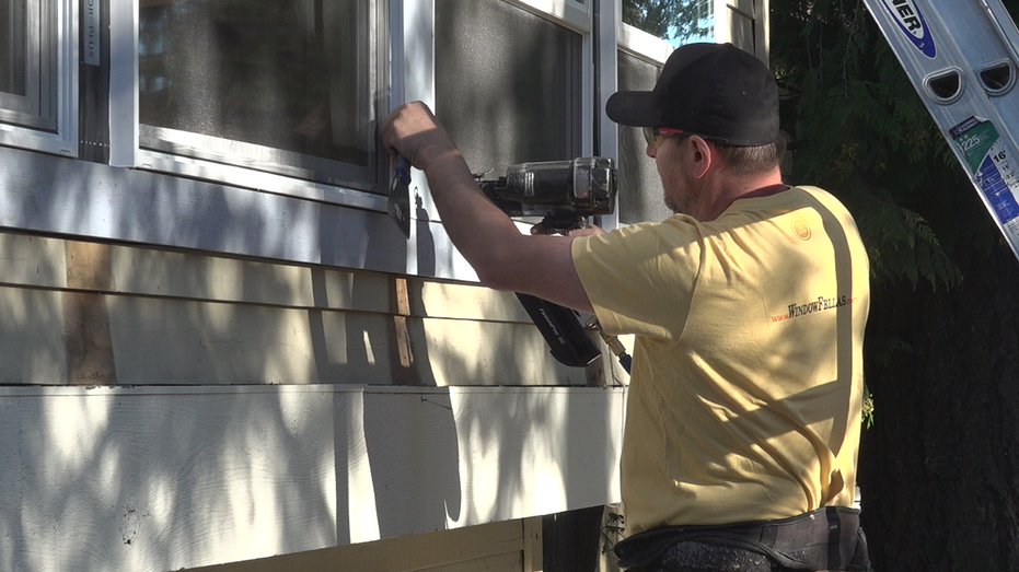 A man working on the outside of a house