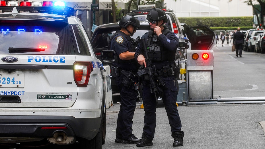 NYPD officers stand by squad car