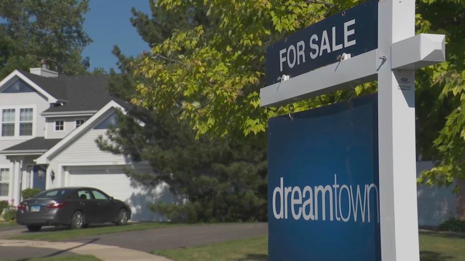 A For Sale sign from the real estate company dreamtown stands outside a home