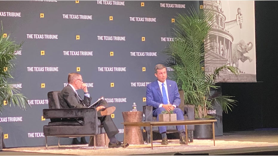 Pete Buttigieg sitting while wearing a blue suit and blue tie