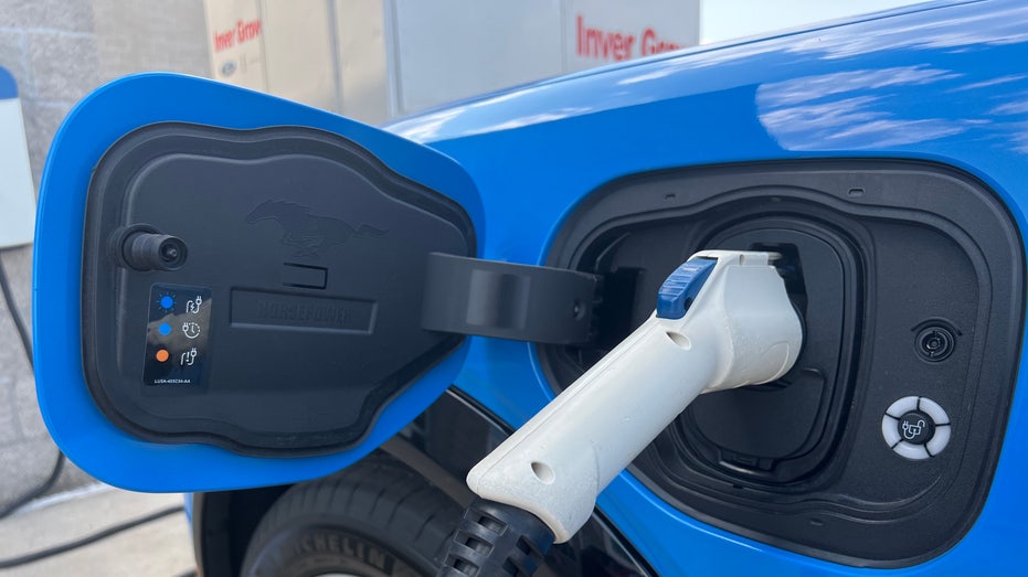 A bright blue electric car is pictured charging