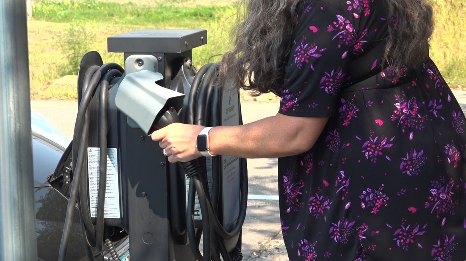 A woman charging her electric vehicle