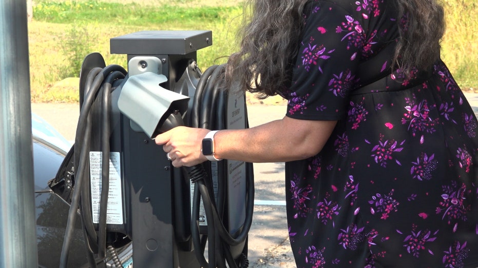 A woman charging her electric vehicle