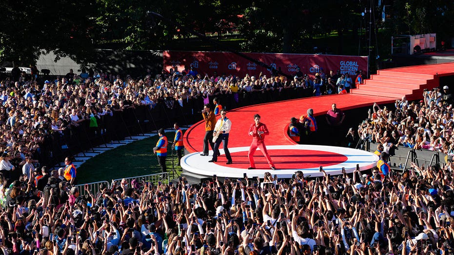 Jonas Brothers perform on a red stage during the Global Citizen Festival