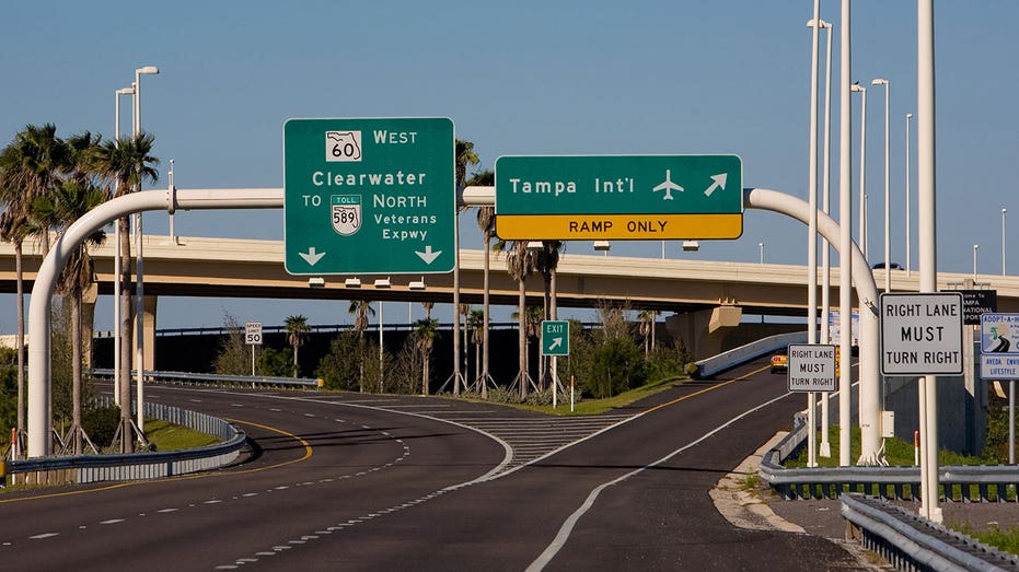 A sign over a highway directs people towards Tampa International Airport
