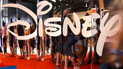 Attendees are reflected in Disney+ logo during the Walt Disney D23 Expo in Anaheim, California on September 9, 2022. 