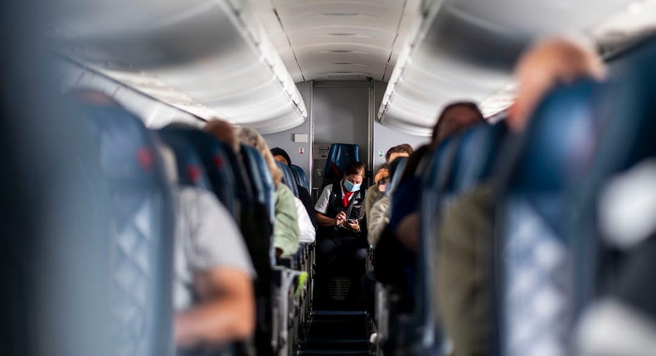 Flight attendant at end of aisle on flight