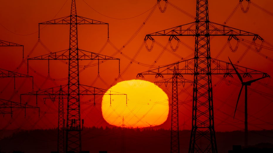 Sun rising behind powerlines