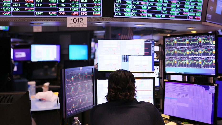 Stock trader stares at computer screens