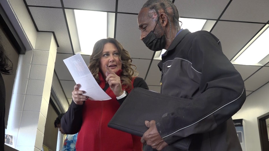 man and woman look at a printed job application