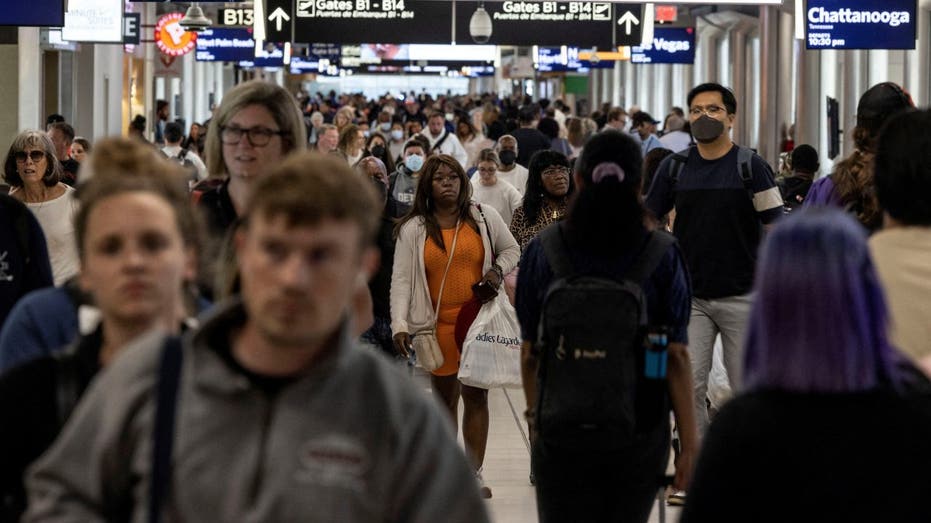 Passengers walk through crowded airport