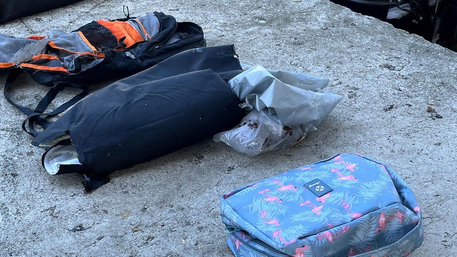 Personal belongings laid out on cement floor