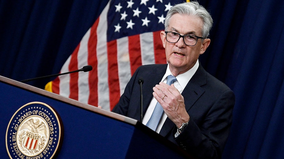 Federal Reserve Chairman Jerome Powell speaking at a podium 