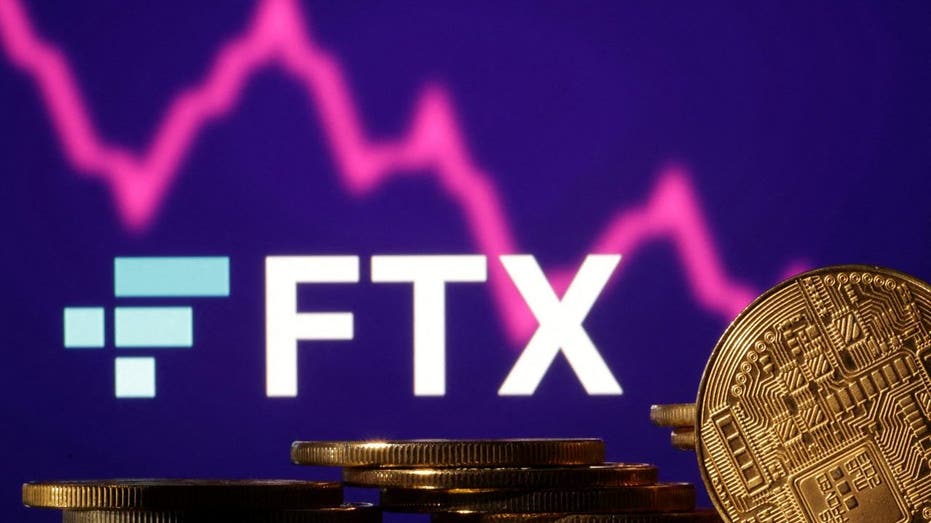 The FTX logo over Representations of cryptocurrencies and a decreasing stock market graph