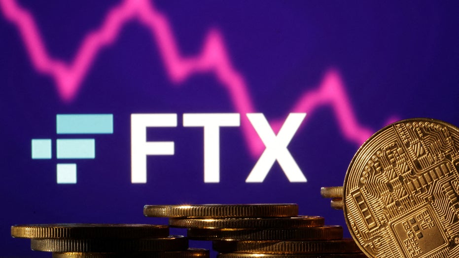 The FTX logo over Representations of cryptocurrencies and a decreasing stock market graph