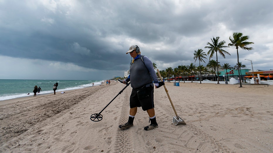 Man with metal detector on beach