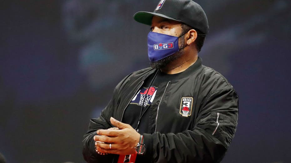 Ice Cube wears a mask at a basektball game