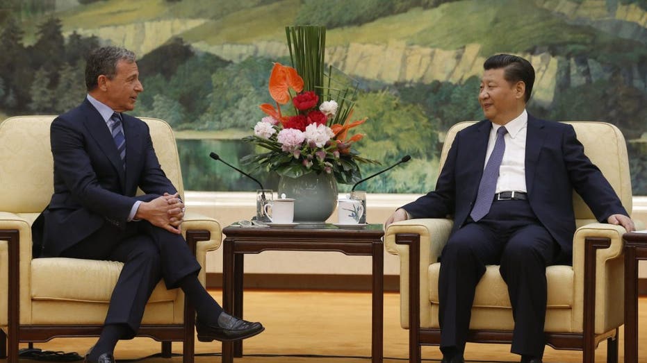 China's President Xi Jinping (R) talks with Chief Executive Officer of Disney Bob Iger