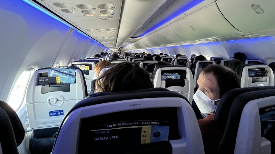 People sit onboard a United Airlines jet aircraft