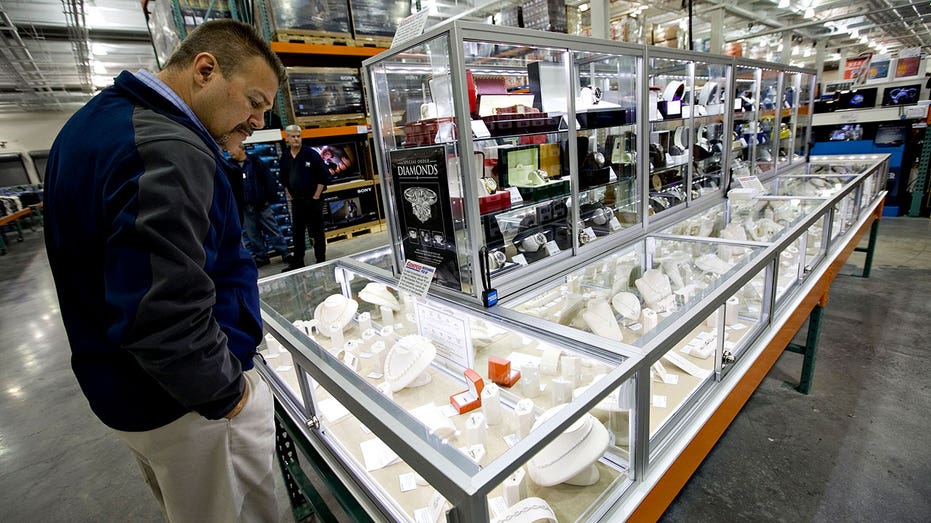 Customer looks into glass jewelry cases at Costco