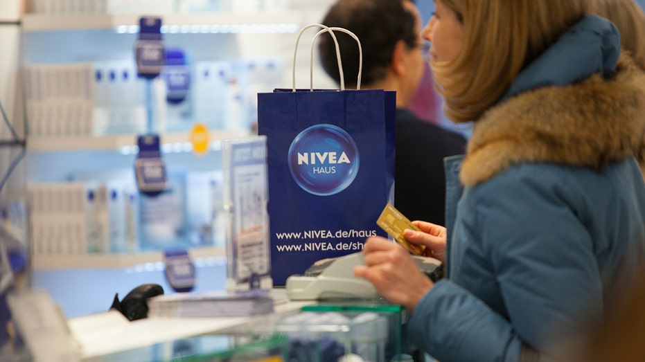 Lady holds credit card while at the cashiers