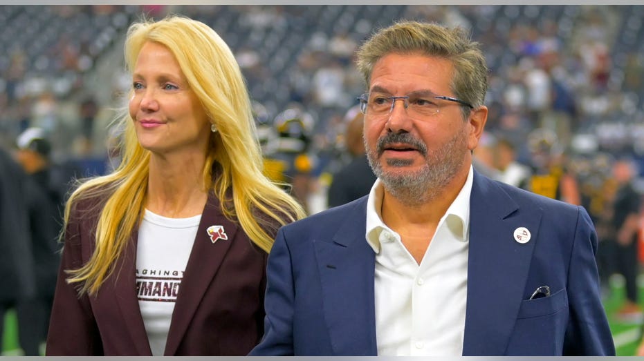 Dan and Tanya Snyder walk on field