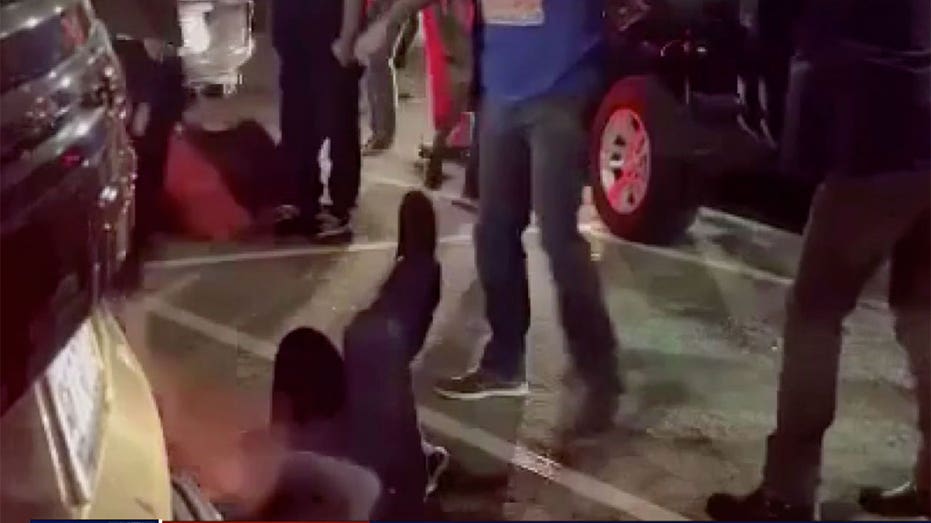 A man is on the floor and punched while another stands over him