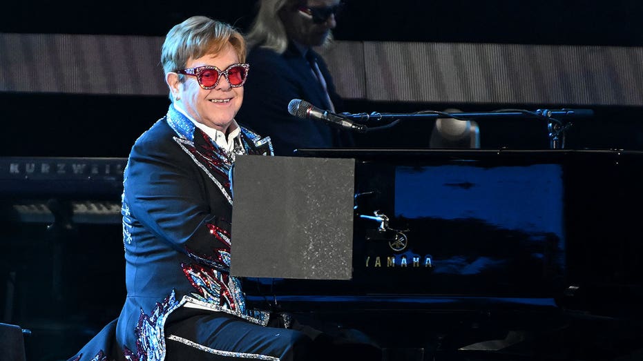 Elton John sits at a piano during his concert at Dodger stadium
