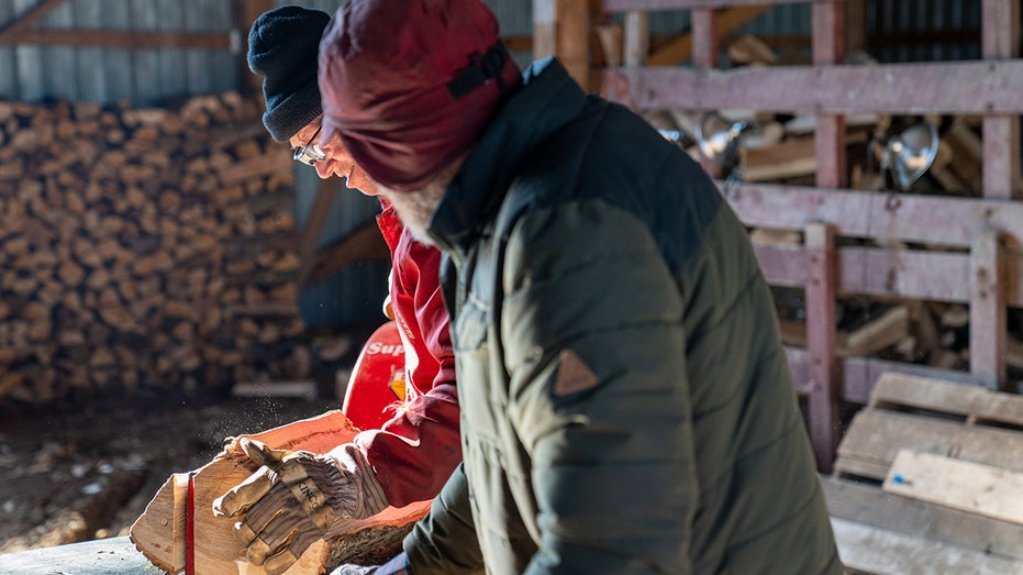 Men splitting wood as they get ready for winter