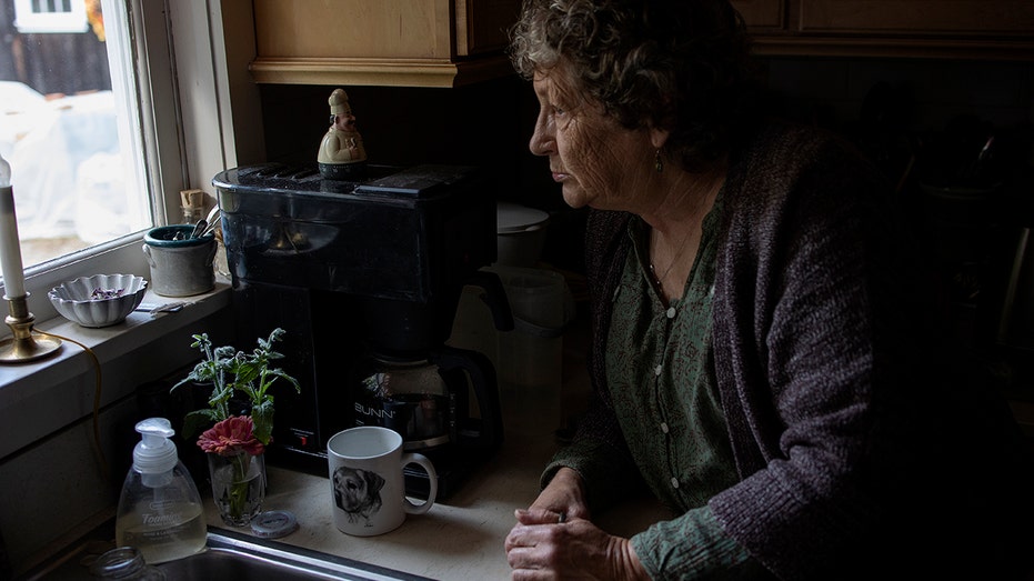 A woman looking out the window as she prepares for winter