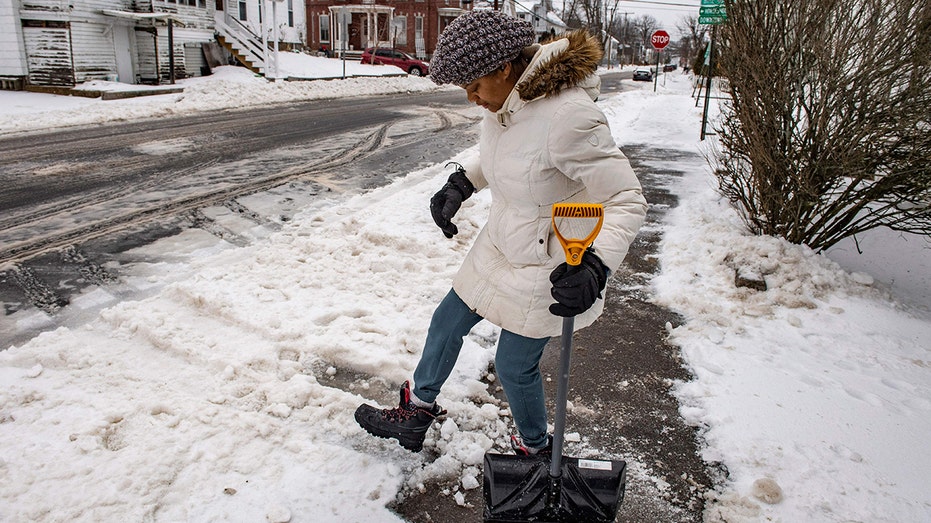A woman shoveling ice in New England