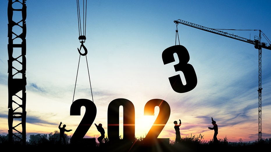 construction workers with crane setting 2023 numbers in place