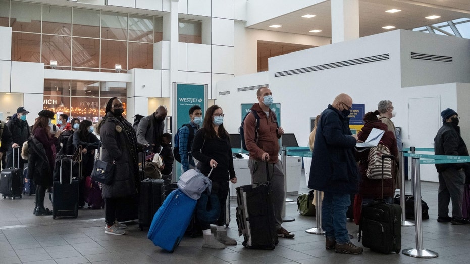 Travelers wait in line to check-in at LaGuardia Airport in New York