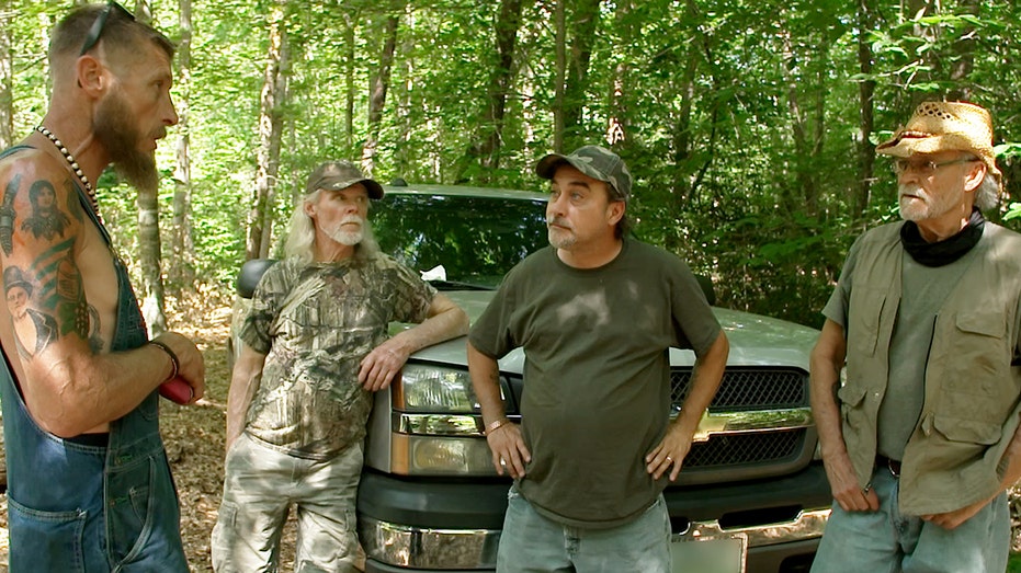 Kenny, Tickle and Henry talking to Josh about his time in the woods.