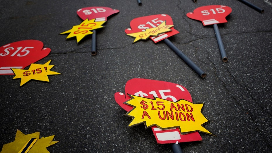 Minimum wage increase signs lie on a street in New York