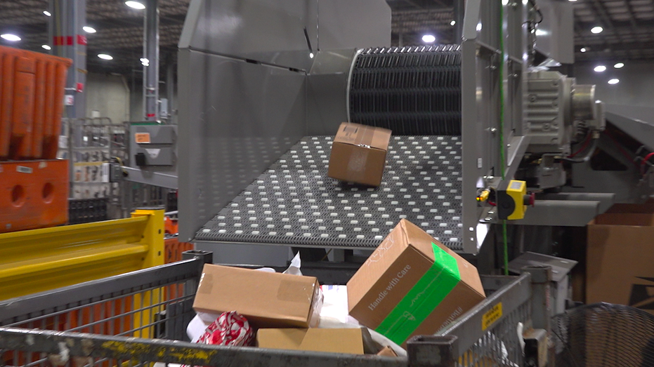 Packages rolling off a sorting machine conveyor belt into a bin