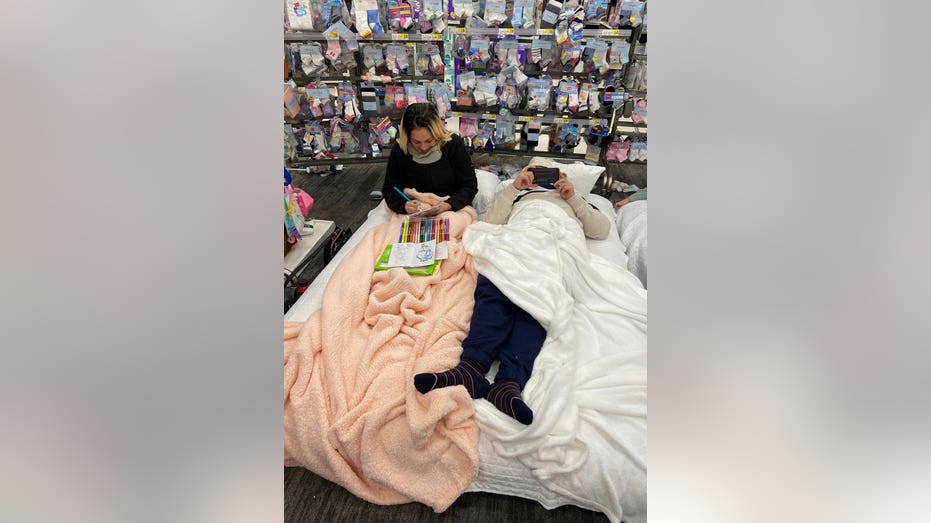 People laying in beds on their phones and with coloring activities at the children's socks section at Target.