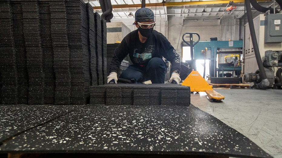 worker stacks tiles at rubber recycline facility