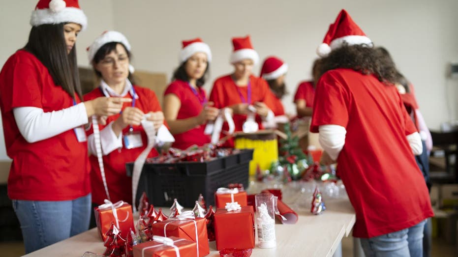 Holiday charity volunteers collect and wrap gifts