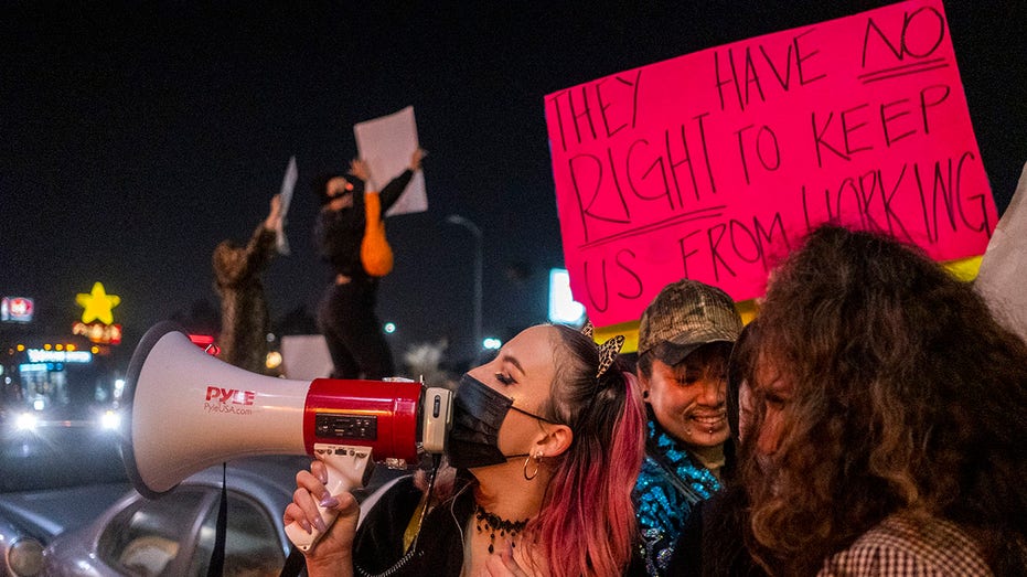 Stripper speaking through bullhorn at protest