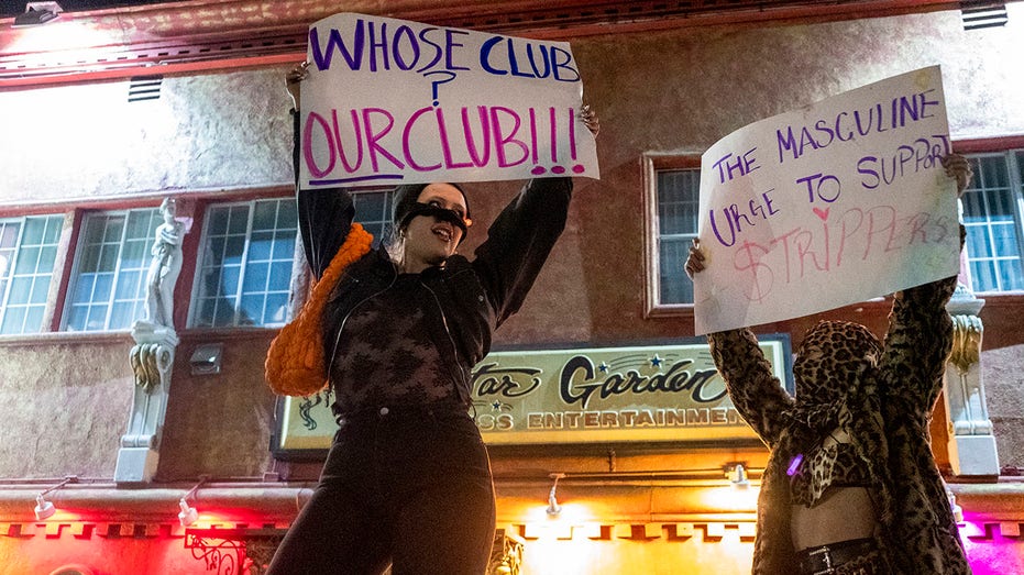 Strippers holding protest signs