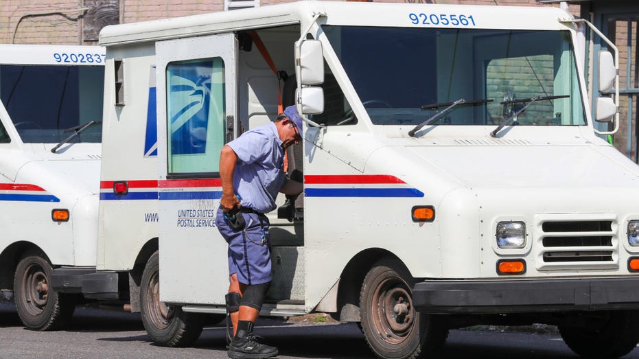 A United States postal worker enters his mail delivery truck