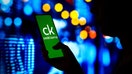 BRAZIL - 2022/04/06: In this photo illustration, a woman&apos;s silhouette holds a smartphone with the Credit Karma logo displayed on the screen. 