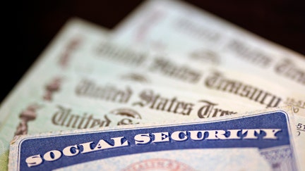 WASHINGTON, DC - OCTOBER 14: In this photo illustration, a Social Security card sits alongside checks from the U.S. Treasury on October 14, 2021 in Washington, DC. The Social Security Administration announced recipients will receive an annual cost of living adjustment of 5.9%, the largest increase since 1982. The larger increase is aimed at helping to offset rising inflation. 